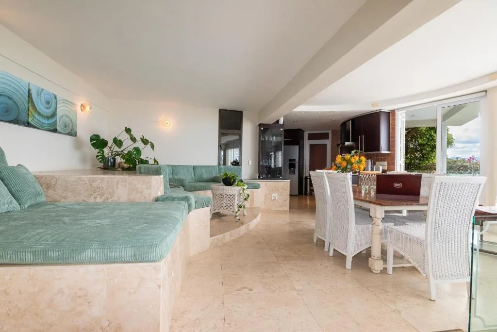 Open-plan lounge with turquoise seating and ocean views through windows