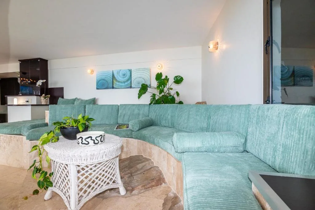 Spacious lounge with turquoise sectional sofa and modern wall art