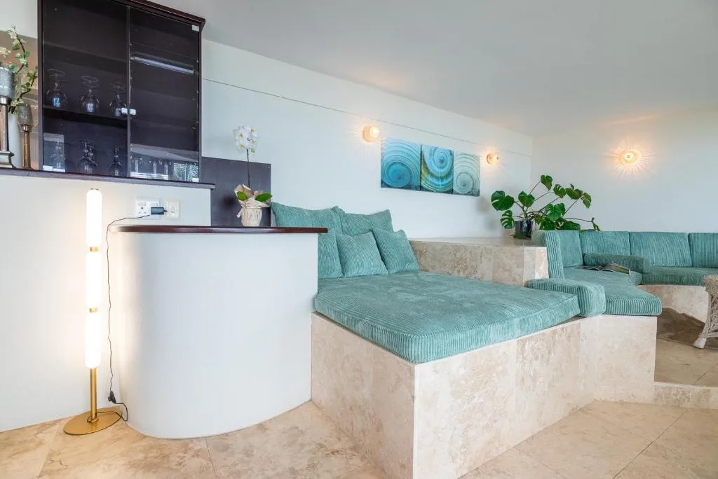 Modern lounge with turquoise seating, wall art, and ambient lighting