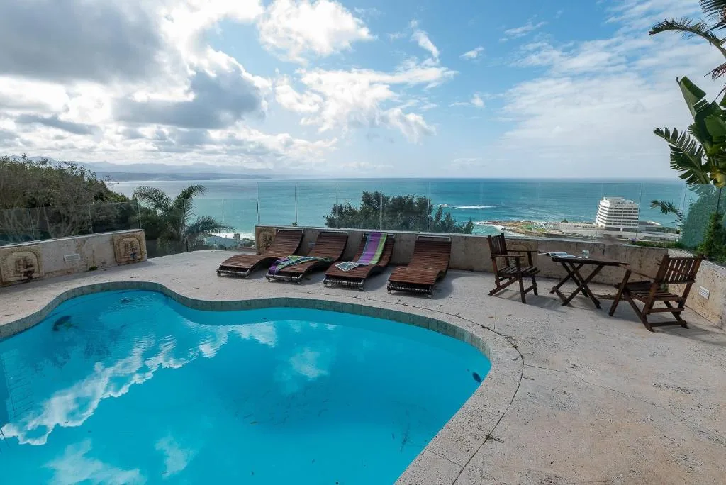 Swimming pool with ocean and coastal views from elevated deck