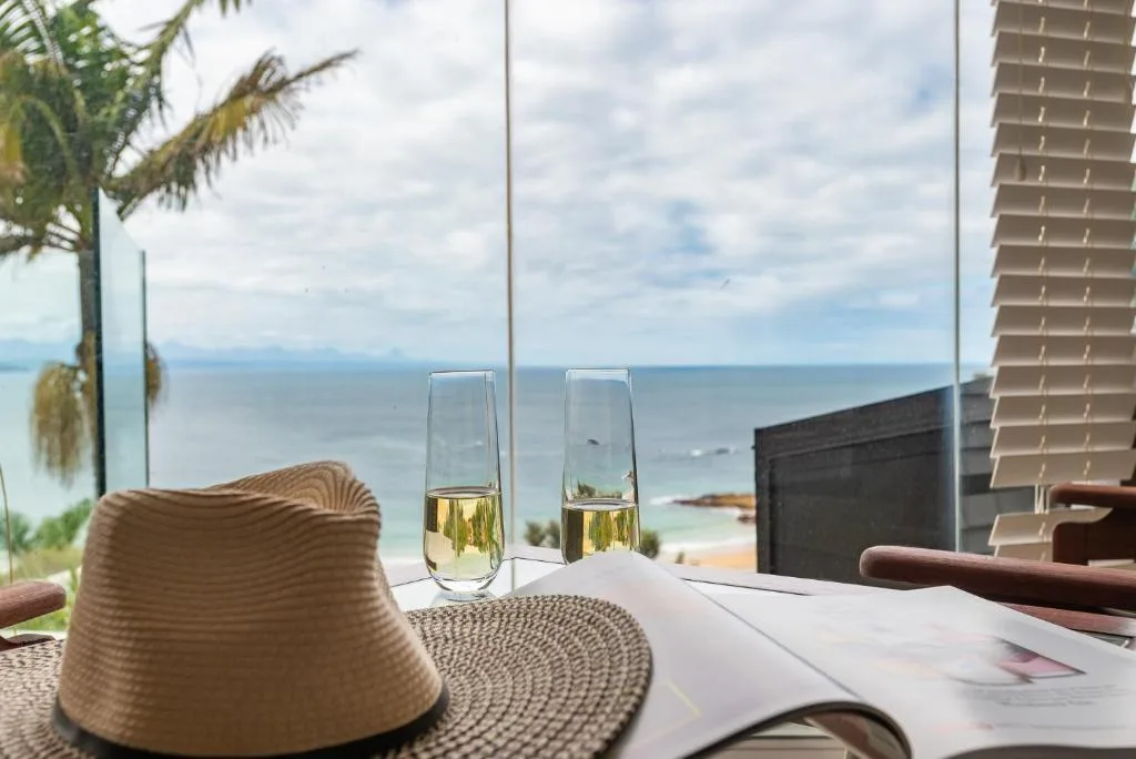 Ocean vista from beachfront deck with champagne glasses and coastal horizon
