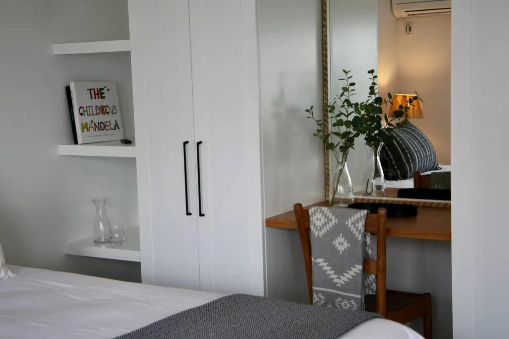 Bright bedroom with white built-in cabinetry and wooden vanity desk