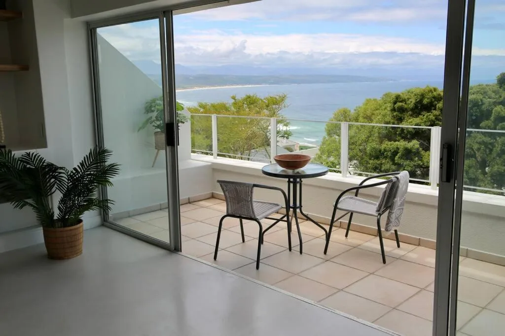 Coastal balcony with seating overlooking bay and mountains
