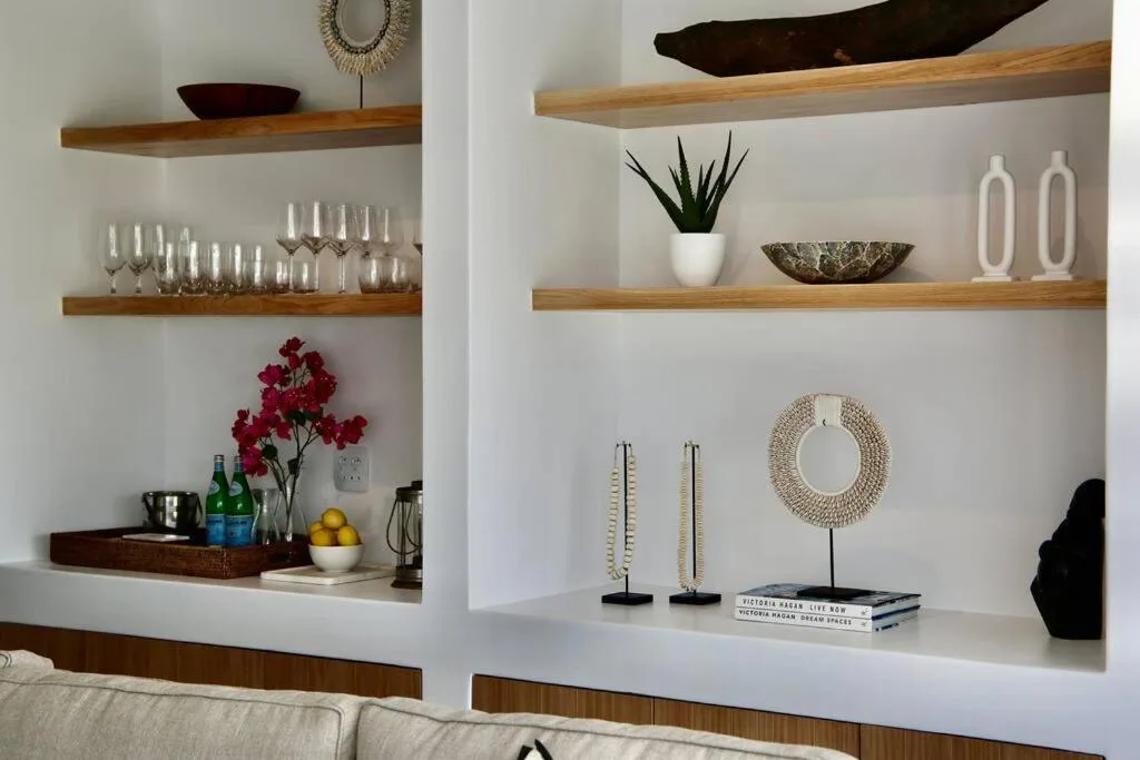 Styled white shelving with wooden accents, decorative objects and modern home accessories