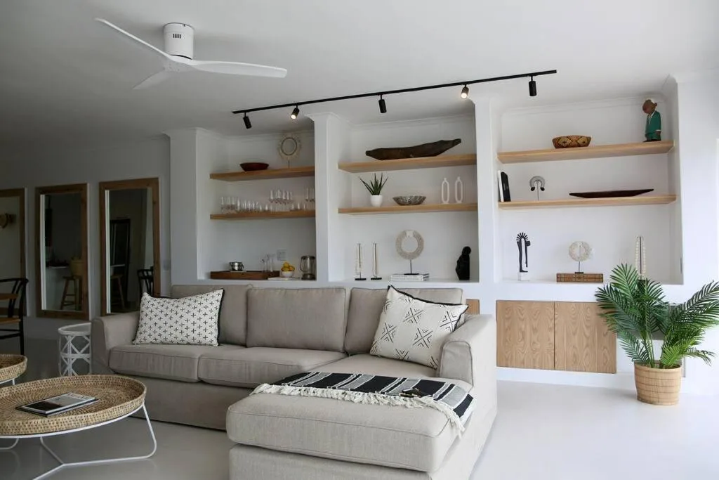 Modern lounge with grey sofa, built-in shelving, and minimalist decor