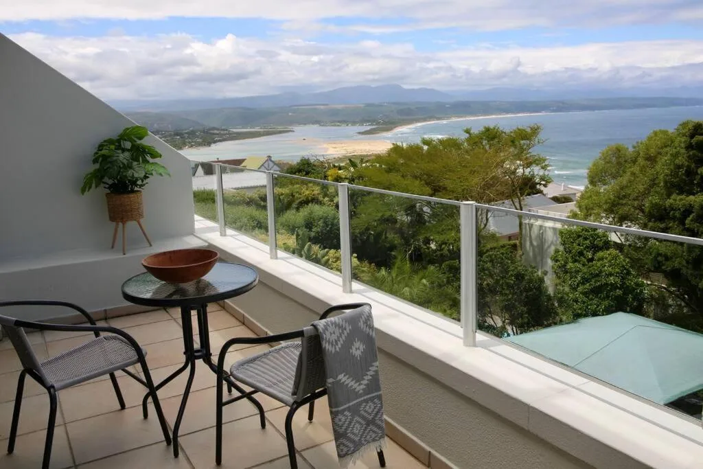 Panoramic coastal view of Plettenberg Bay beach and mountains from balcony
