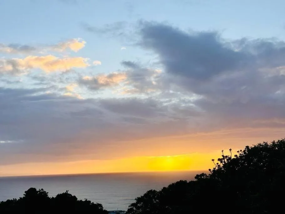 Dramatic sunset over the ocean with golden and purple clouds