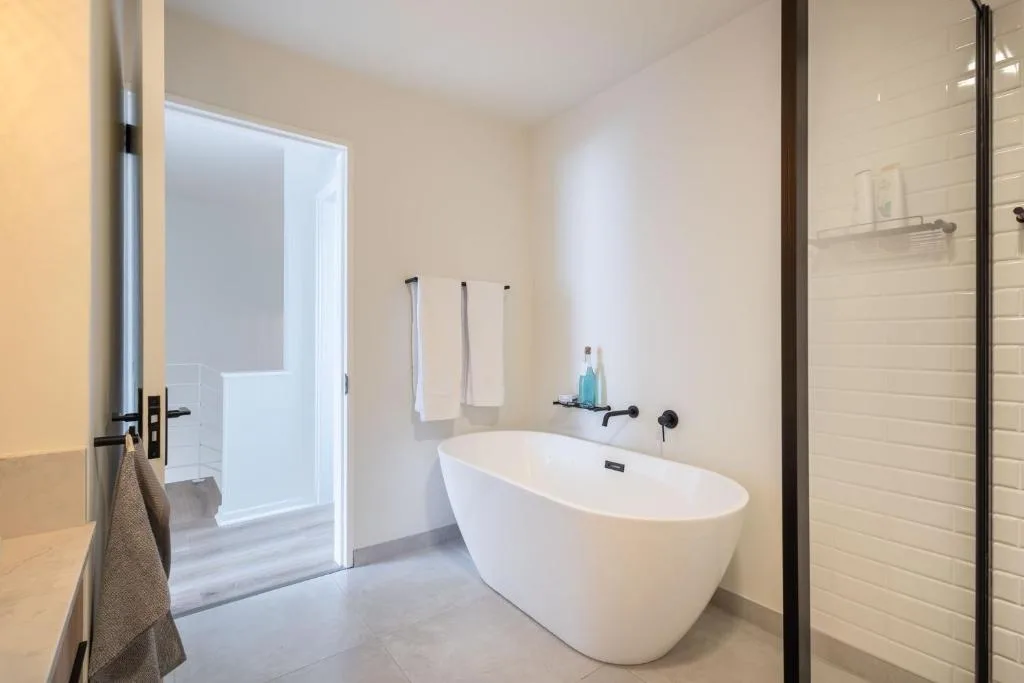 Modern bathroom with freestanding white bathtub and walk-in shower enclosure