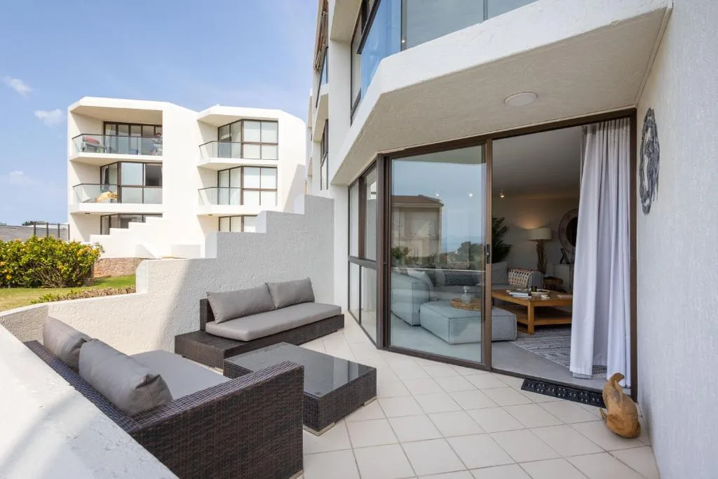 Modern patio with rattan furniture overlooking contemporary apartment building
