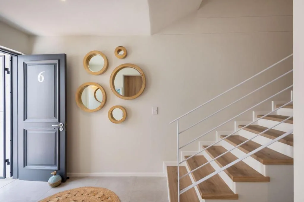 Interior hallway with wooden mirror wall art and modern staircase
