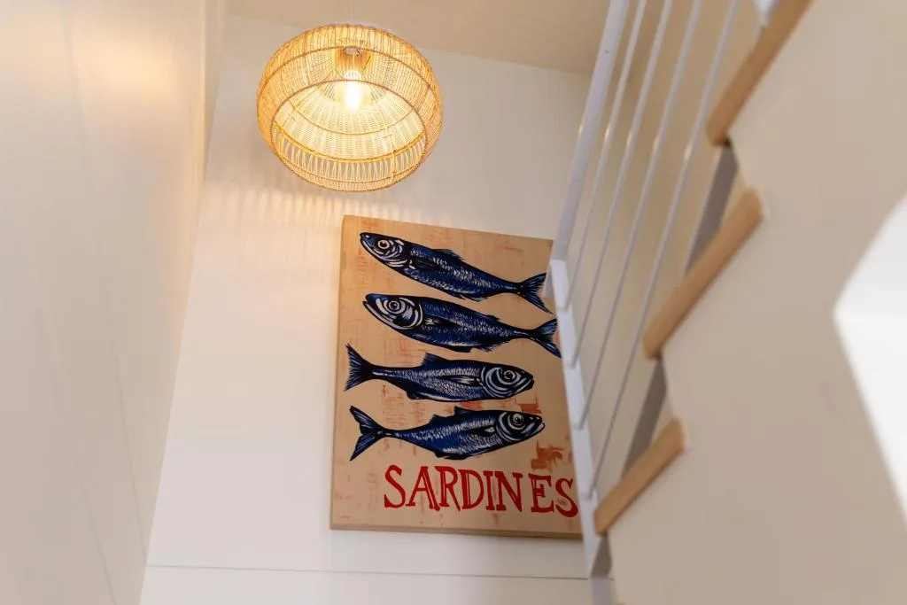 Coastal-themed sardines artwork and woven ceiling light fixture
