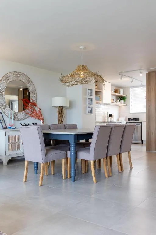 Modern dining area with blue table and gray upholstered chairs