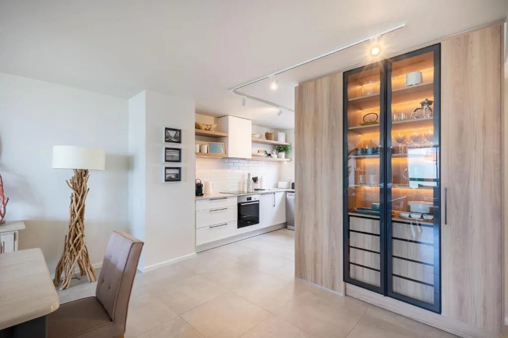 Modern open-plan kitchen with white cabinetry and stainless steel appliances