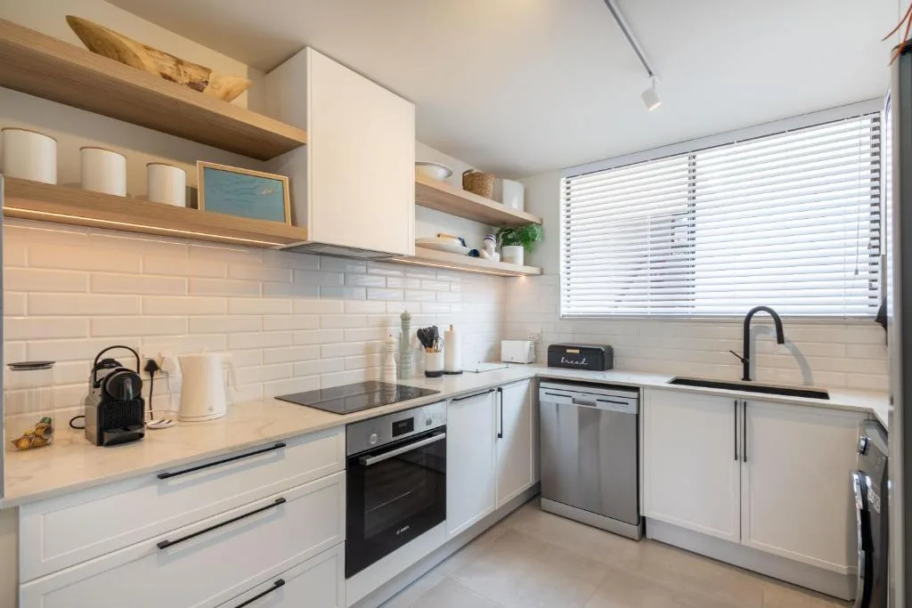 Modern white kitchen with stainless steel appliances and subway tile backsplash