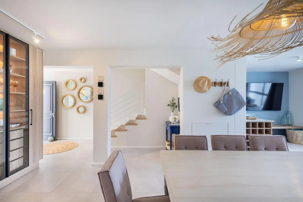 Modern lounge with grey upholstered chairs, wall-mounted TV, and decorative mirrors