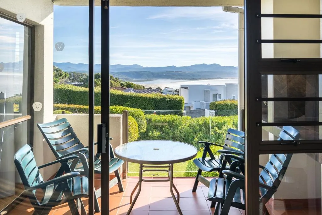 Outdoor patio with seating overlooking lagoon and mountains