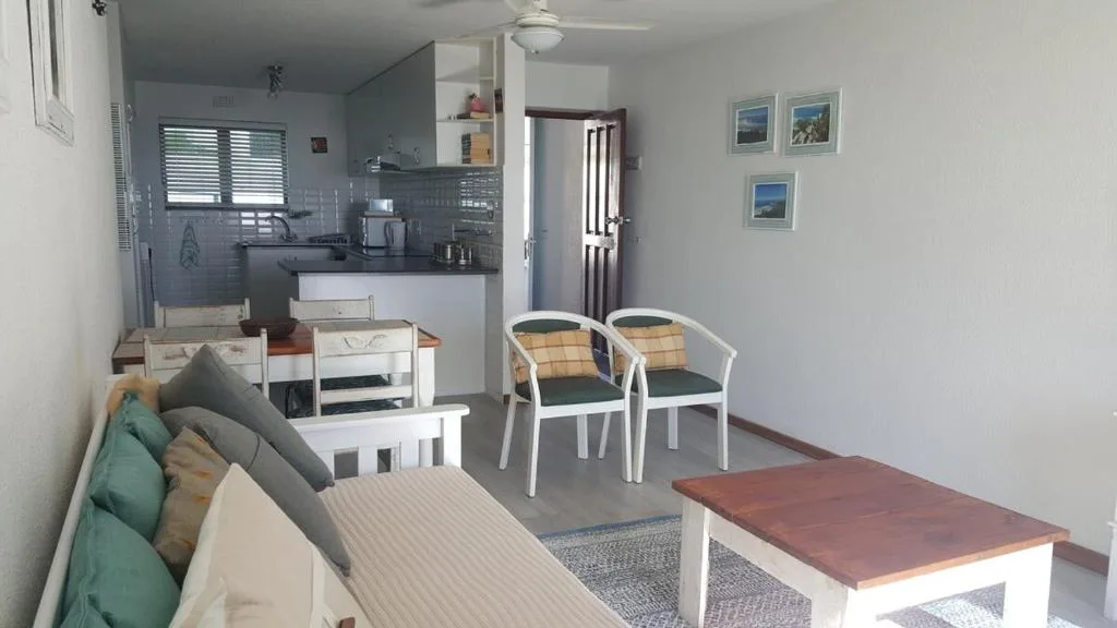 Open-plan living area with sofa, armchairs, and coffee table