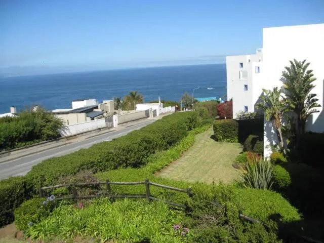 Ocean and coastal landscape visible from manicured property gardens