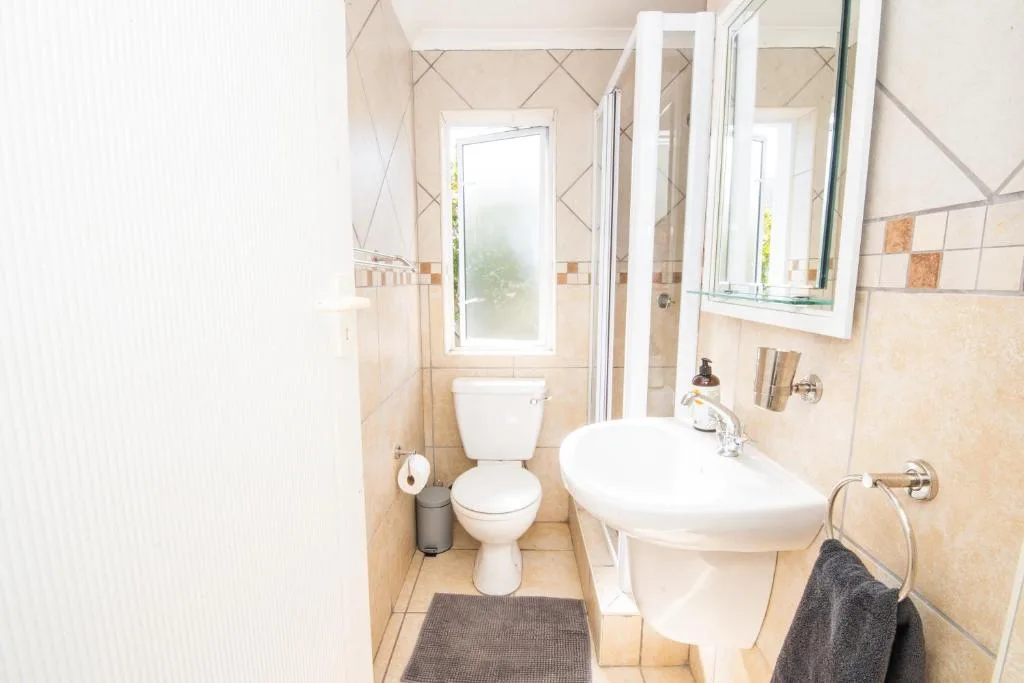 Clean bathroom with toilet, pedestal sink, and mirrored cabinet