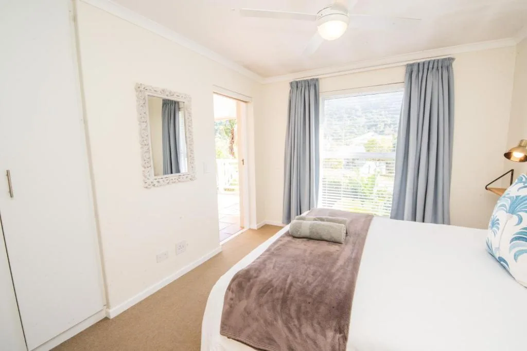 Bright bedroom with queen bed, large window, and scenic valley views