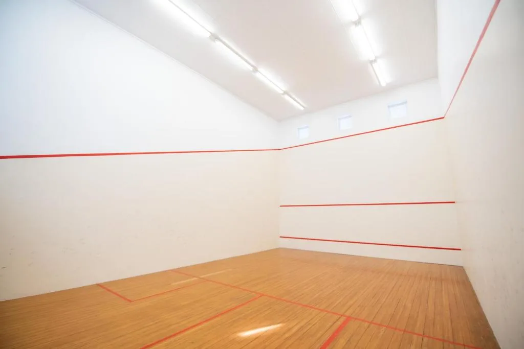 Indoor squash court with wooden floor and red line markings