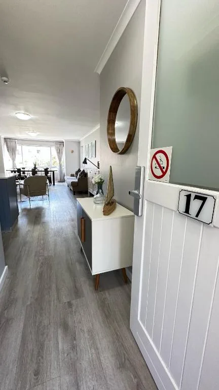 Modern hallway entrance with wooden mirror and apartment number seventeen sign