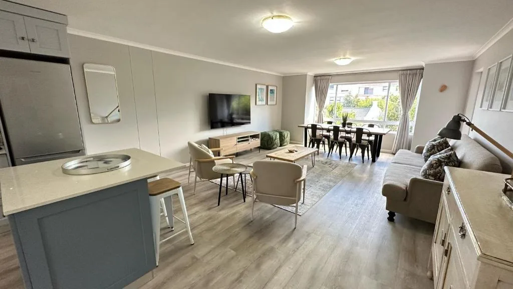 Open-plan lounge with sofa, TV, and dining area visible