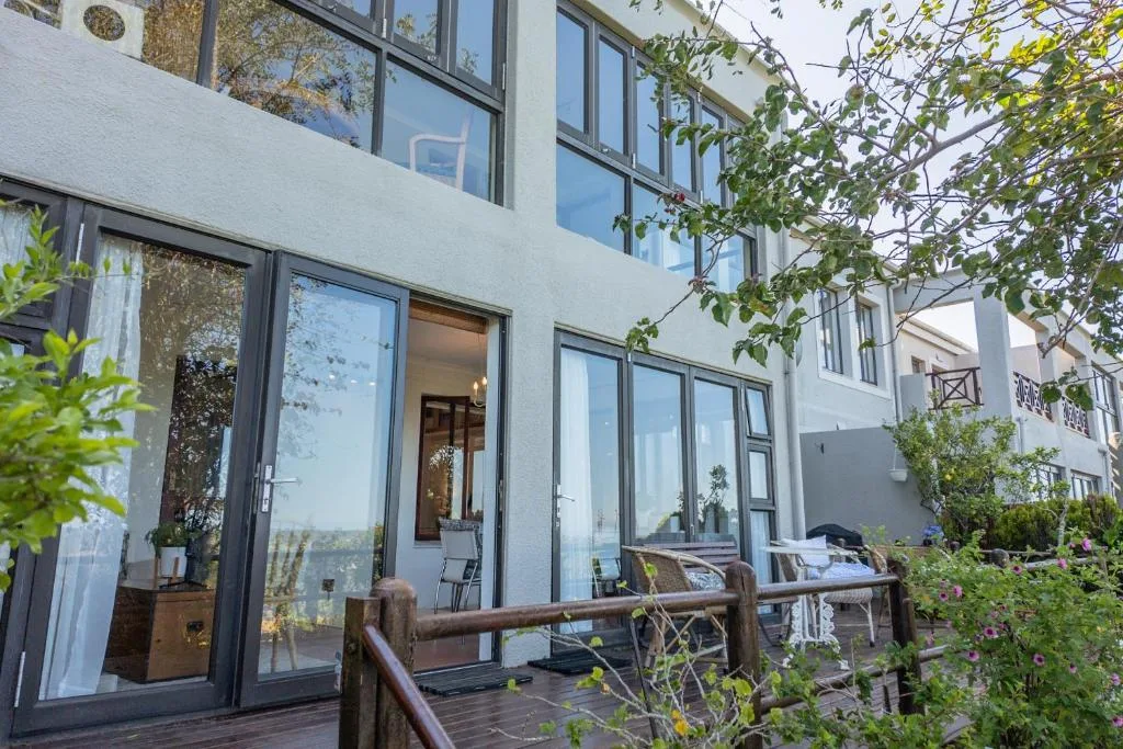 Modern wooden deck with seating overlooking manicured gardens and valley views