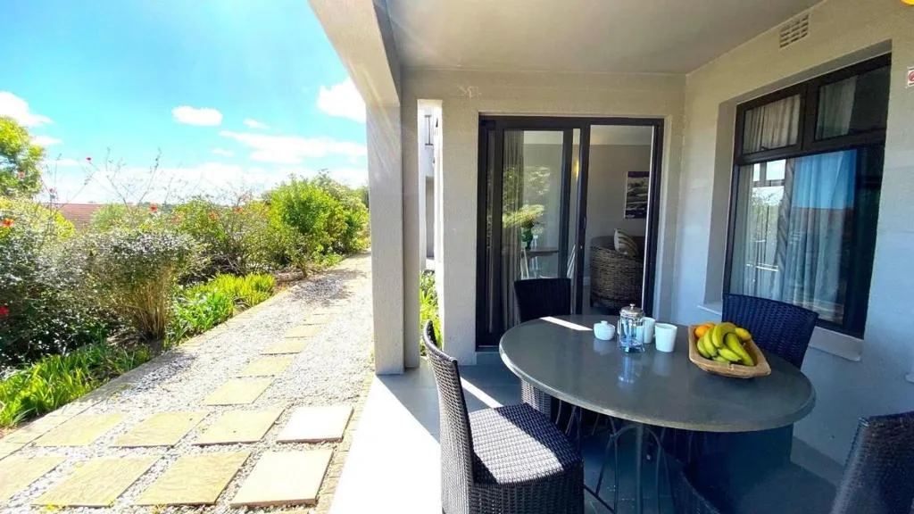 Covered patio with outdoor dining table and garden views