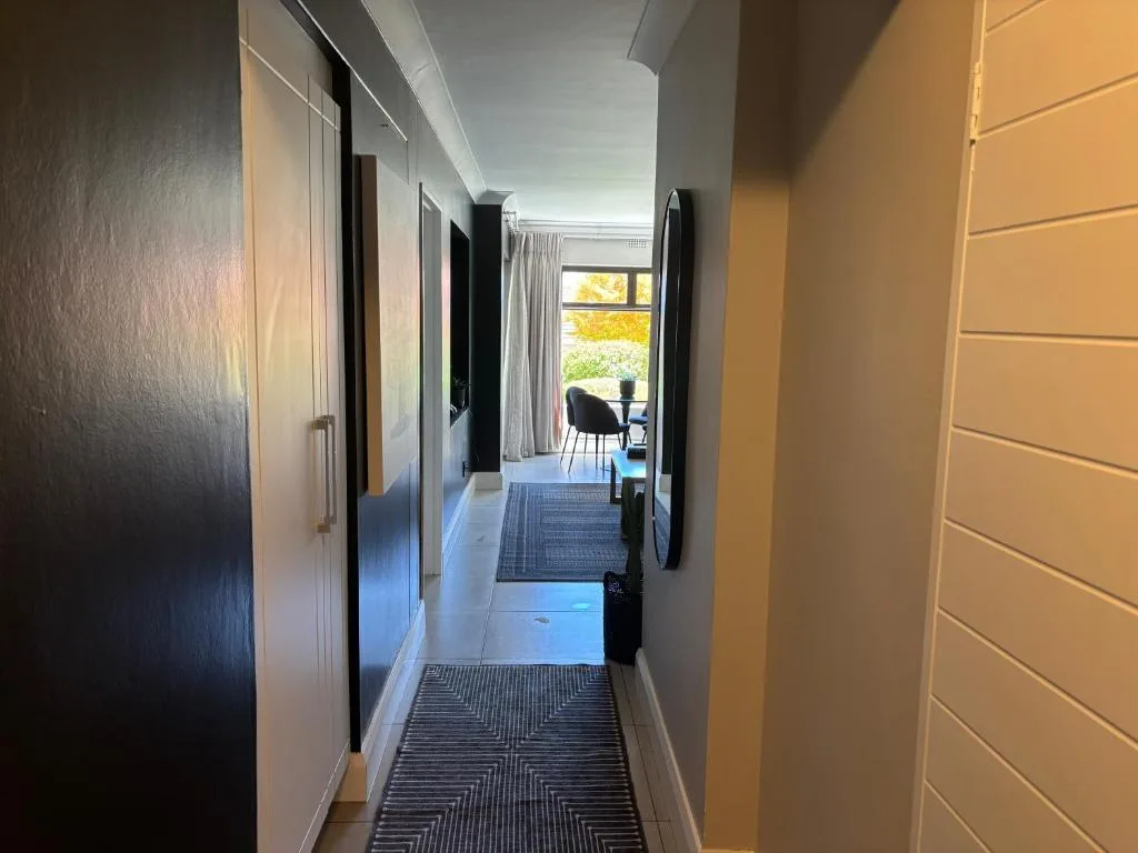 Modern hallway with geometric runner rug and multiple doors