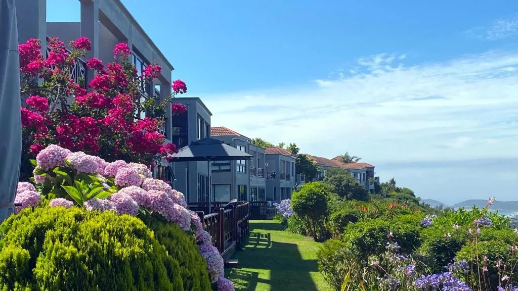 Modern apartment buildings with vibrant magenta bougainvillea and manicured gardens