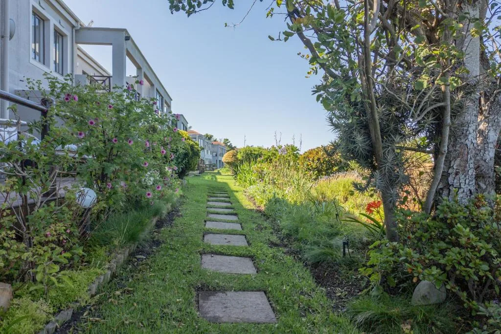Garden pathway with stepping stones leading to white apartment building