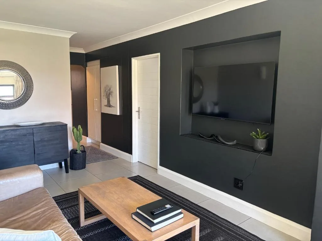 Modern lounge with wall-mounted TV, wooden coffee table, and contemporary furnishings