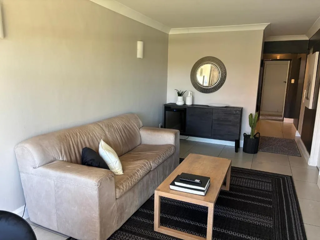 Comfortable beige leather sofa with wood coffee table in bright living room