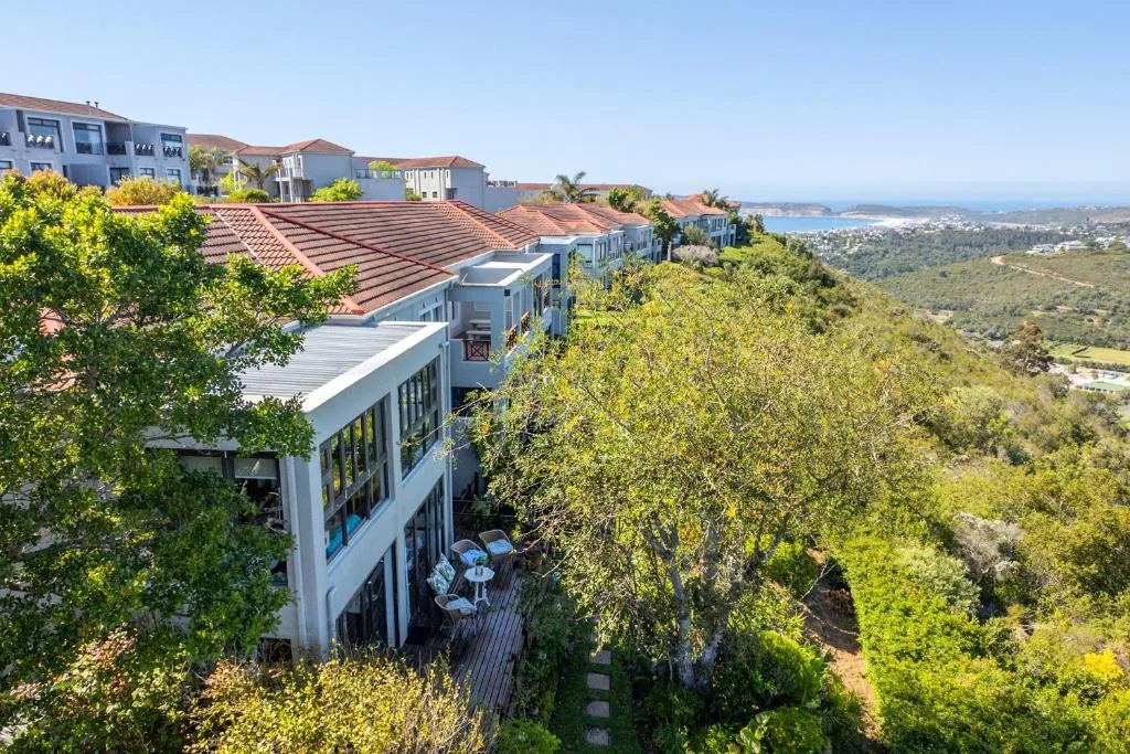 Hillside apartments overlooking lush valley and distant coastal landscape