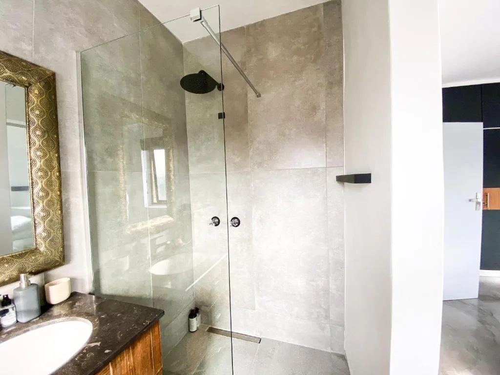 Modern bathroom with walk-in shower enclosure and vanity mirror