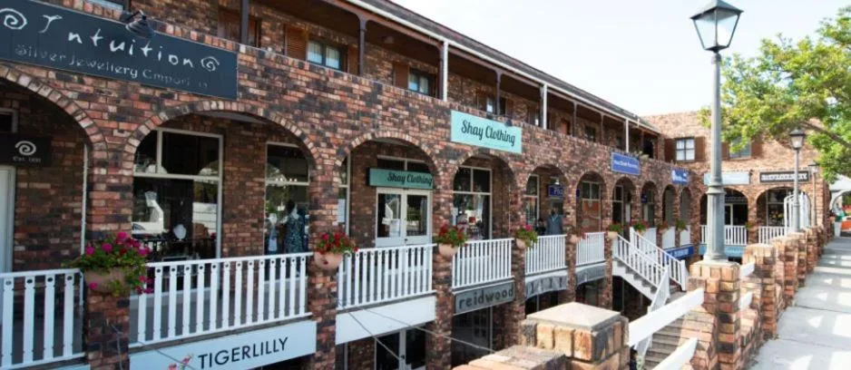 Victorian brick building with white railings and shop fronts on Main Street