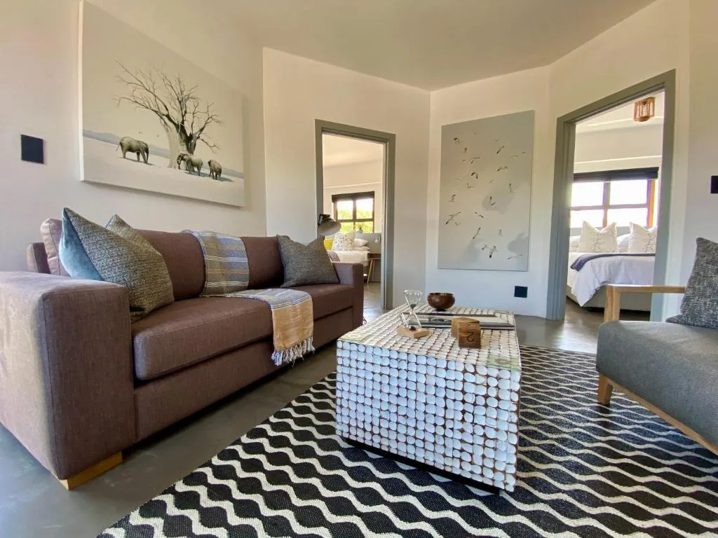 Modern lounge with brown sofa, patterned cushions, and woven coffee table