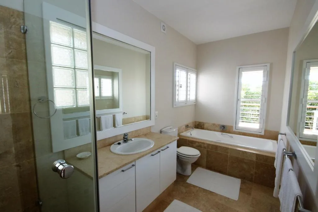 Spacious bathroom with walk-in shower, dual vanity, bathtub and natural light