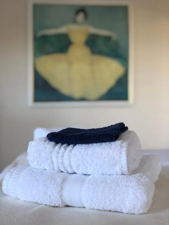 Stacked white towels with black sock detail and framed artwork