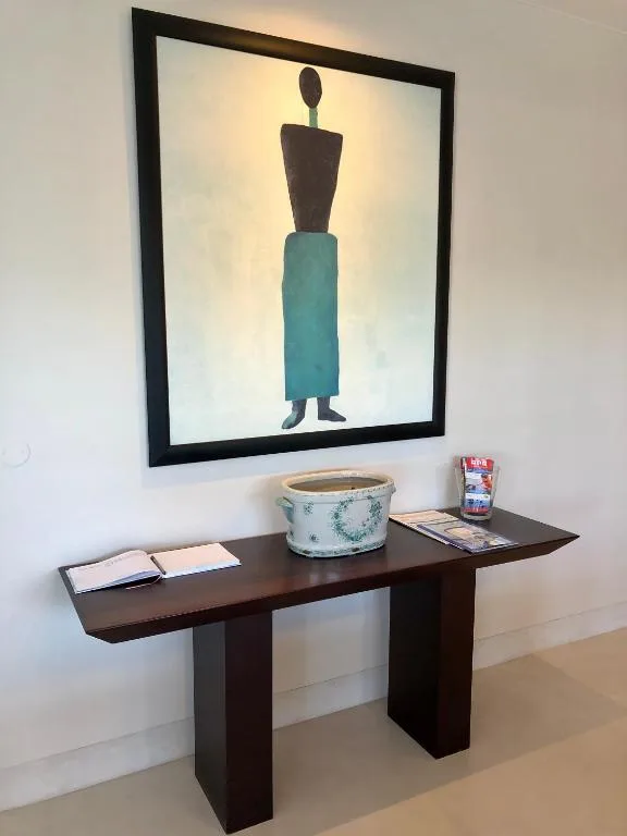 Modern apartment entryway with console table, decorative artwork, and accessories