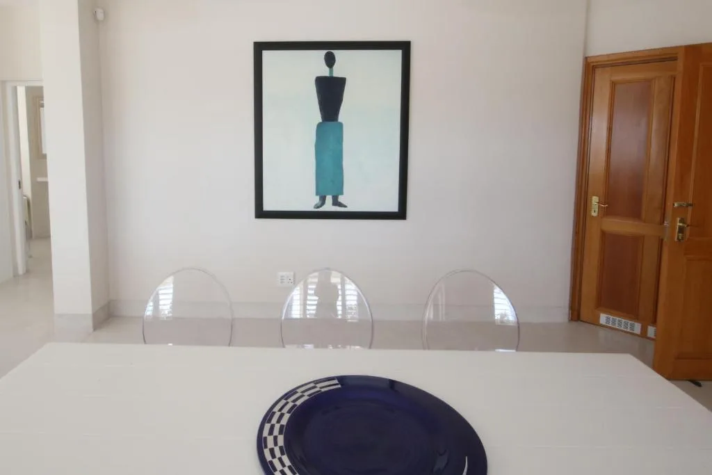 Modern dining table with clear chairs and contemporary wall art