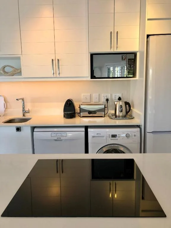 Modern kitchen with white cabinetry, stainless steel appliances, and compact layout