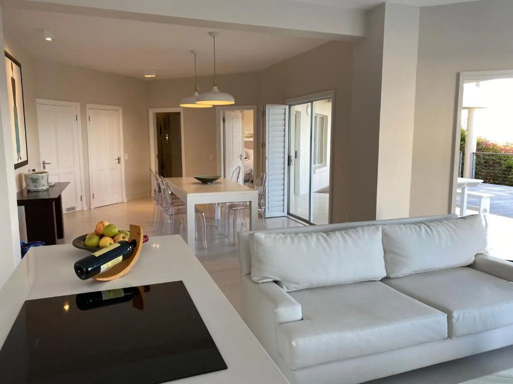 Modern lounge with cream sofa, white countertop, and open-plan living space