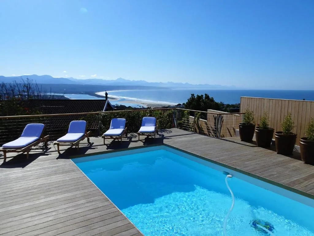 Swimming pool with loungers overlooking coastal mountain views