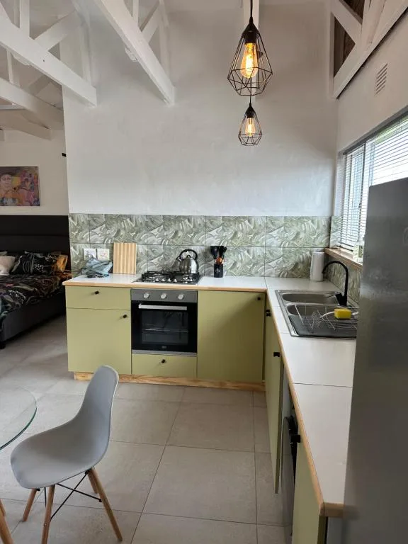 Modern kitchen with yellow cabinetry, gas stove, and pendant lighting