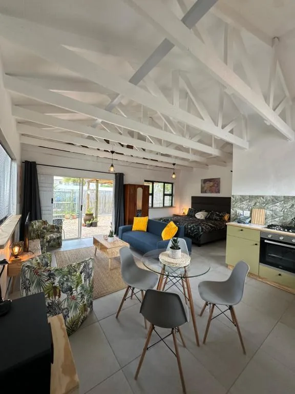 Open-plan lounge with vaulted ceilings, blue sofa, and dining area