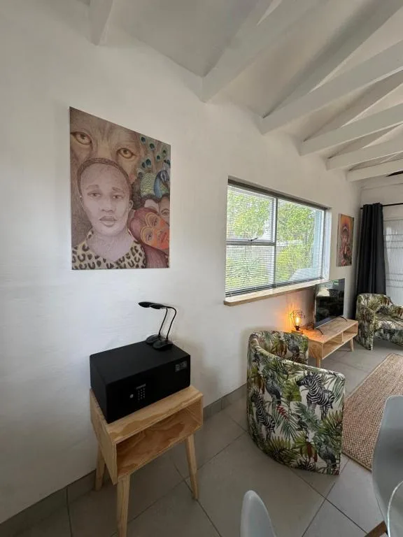 Modern lounge area with patterned armchairs and large windows overlooking garden