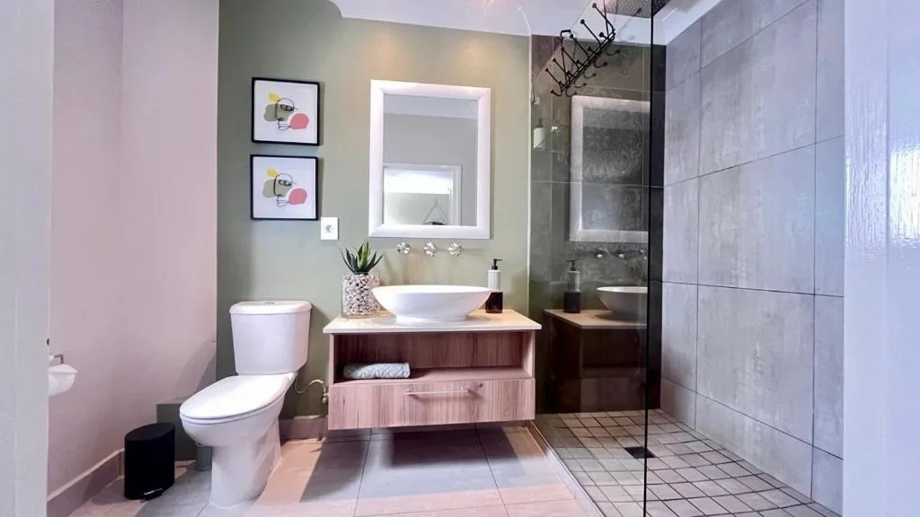 Modern bathroom with vessel sink, illuminated mirror, and walk-in shower