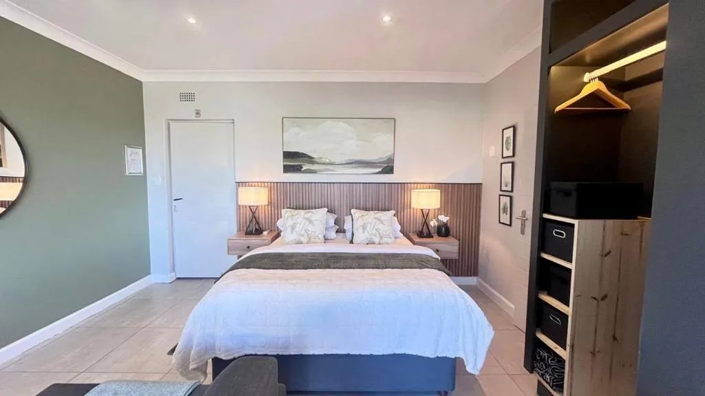 Spacious bedroom with queen bed, feature headboard, and modern furnishings